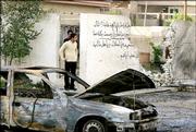 Iraqi men survey the site of a U.S. backed raid on a Shiite neighborhood in Baghdad Monday March 27, 2006 in Baghdad. At least 16 Iraqis were killed in a U.S. backed raid in a Shiite neighborhood of the capital on Sunday evening.