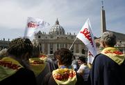 Polish pilgrims, wearing scarves and holding flags of the Solidarity pro-democracy movement, arrive in St. Peter's Square at the Vatican on Saturday, a day before the one-year anniversary of the death of Polish-born Pope John Paul II. Pilgrims have begun arriving in Rome to mark the first anniversary of John Paul II's death, praying by his tomb and preparing for an evening vigil in St. Peter's Square today to commemorate the exact time of his passing. In the background is St. Peter's Basilica.