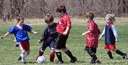 Blue team's Oisin Thompson, center, controls the ball Saturday in the 7U match-up at Youth Sports Inc. The high-scoring game ended with the Red team winning 9-7.
