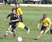 Force White's Jacob Walters advances the ball toward the goal as he is being chased by a Blue Valley Star Barcelona player during Saturday's game at Youth Sports Inc. The Force won 6-2.