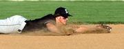 Free State High third baseman Kyle Cross dives for a first-inning grounder during the Firebirds' 12-1 rout of Lawrence High. FSHS beat its city rival Tuesday at Ice Field.