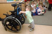 Joshua Evans didn't have any problem getting back into the swing of things at Langston Hughes Elementary school Tuesday as the kindergarten student puts up some pictures from show-and-tell.