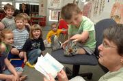 Josh Evans didn't have any problem getting back into the swing of things at Langston Hughes School. The kindergarten student listened Tuesday to his teacher Linda Browning, right, as she read cards welcoming Josh back after his trip to Disney World, courtesy of the Dream Factory of Greater Kansas City. Josh has a genetic disorder that affects his bone development.