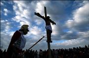 People watch Jose Vega on the cross as Jesus a during procession on Good Friday during holy week celebrations, in La Paz Bolivia, Friday, April 14, 2006.