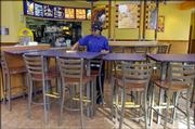 Dipika Patel, of Lawrence, works at the renovated Taco Bell restaurant at Sixth and Michigan streets. The new interior of the store is brighter and has more modern-looking furniture.