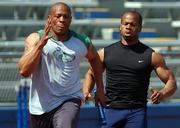 Maurice Greene, left, takes the baton from teammate Kaaron Conwright during a practice session Thursday.