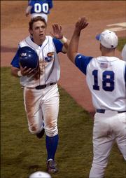 KU's John Allman is congratulated by starting pitcher #18 Sean Land, after Allman hit a seventh-inning triple and drove in two runs to give KU the lead over Kansas State 7-5.