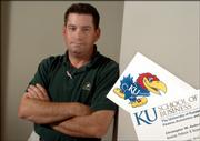 Christopher Anderson, associate professor in the School of Business has a Jayhawk logo on the back of each of his business cards. This flies in the face of new KU standards that place the beloved Jayhawk only on the business cards and stationary of those in the athletic department and the alumni association.