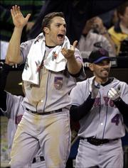 New York Mets' David Wright (5) and Chris Woodward lead the team out of the dugout in celebration as the Mets' Julio Franco's two-run home run gave the Mets a 3-2 lead in the eighth inning against the San Diego Padres, in this April 20, 2006 file photo in San Diego. With uncommon poise, perspective and get-dirty enthusiasm, Wright is becoming one of baseball's toughest outs and a Big Apple icon all at once.