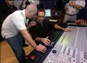 Hip-hop star Pitbull, left, whose real name is Armando Perez, talks with producer Eduardo Reyes as he mixes a track while recording a Spanish-language version of the U.S. national anthem, Wednesday, April 26, 2006 in Miami. The recording, dubbed "Nuestro Himno," which means "Our Anthem" in English, is set to "rhythmic Latin musical arrangement" but respects the song&squot;s traditional structure, said Adam Kidron, who heads the record label Urban Box Office.