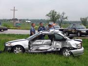 Douglas County Sheriff's officers work the scene of a fatal accident Saturday afternoon near the intersection of U.S Highways 59 and 56, about 10 miles south of Lawrence. The driver of the silver car was pronounced dead at the scene.