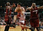 Chicago's Kirk Hinrich, center, passes under pressure from Miami's Dwyane Wade, left, and Antoine Walker. Hinrich helped the Bulls to a 93-87 victory Sunday in Chicago.