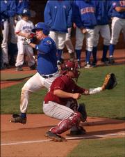 KU catcher Andrew Spitzfaden eludes OU's Jon Shackelford at home plate in the fifth inning of Game Two. The Jayhawks scored five runs that inning.