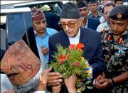 Nepal's newly appointed Prime Minister Girija Prasad Koirala, center, receives flowers from an official at the prime minister's office in Katmandu, Nepal. Koirala on Sunday urged Maoist rebels to sit down for peace talks as he began the challenge of keeping his political alliance together and steering this troubled Himalayan country toward peace and democracy.
