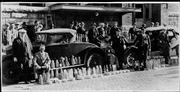 Lawrence law enforcement pose with 200 quarts of illegal whiskey confiscated in a raid in this photo dated April 5, 1927. The photo was taken outside the police headquarters. The man seated on the running board is Will Johns, chief of police.