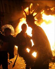 Youths dance in front of burning barricades during clashes in the Berlin district of Kreuzberg late Monday May 1, 2006. German police clashed with May Day revellers and demonstrators as labor unions and workers across Europe held events to protest unemployment, poor working conditions and low wages.