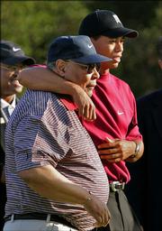 Tiger Woods, right, hugs his father, Earl, after winning the Target World Challenge, Sunday, Dec. 12, 2004, in Thousand Oaks, Calif. Earl Woods, who was more determined to raise a good son than a great golfer and became the role model, architect and driving force behind Tiger Woods' phenomenal career, died Wednesday morning May 3, 2006 at his home in Cypress, Calif. He was 74