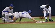 Kansas City Royals' Paul Bako dives back after overrunning third base to beat the tag by Twins third baseman Tony Batista in front of Royals third-base coach Luis Silverio. The Royals defeated the Twins, 1-0, Thursday night in Minneapolis.