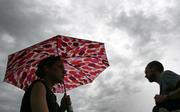 Pedestrians scurry along the sidewalk at Kansas University as storm clouds hover overhead Wednesday. The Lawrence area received almost four inches of rain this week.