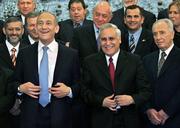 Israeli Prime Minister Ehud Olmert, front left, straightens his jacket as he stands with new ministers including Vice Premier Shimon Peres, middle front, and Israeli President Moshe Katsav, front right, during the official photo at the President's House in Jerusalem. Olmert was sworn in Thursday as Israel's prime minister, leading a coalition he hopes can carry out his main campaign pledge: to set permanent national borders by withdrawing Jewish settlers from parts of the West Bank.