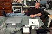 Paul Ulasien relaxes in his home office in west Lawrence, focused on selling his new book, "The Corporate Rat Race: The Rats Are Winning."