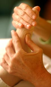 Lawrence resident and reflexologist Julie Vernon applies pressure to client Sarah Fayman's feet during a session Wednesday afternoon in Vernon's home. Vernon explained that with reflexology, problems throughout the body can be targeted by working through the feet.