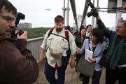 Steve Vaught, left, surrounded by the media, completes his approximately 3,000-mile walk across the United States by crossing the George Washington Bridge into New York City. Vaught completed his trek Tuesday, more than a year after he began in California.