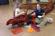 Erika O&squot;Shea, left, and Jenn Crawford,wrap a 40-foot dragon in cloth and paper for this weekend&squot;s production of "The Hobbit."