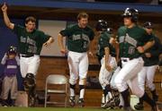 Free State High players Andy Petz (20) and Brett Lisher (14) celebrate the winning run against Lawrence High. The Firebirds scored the winning run in the bottom of the seventh inning, beating the Lions, 6-5, Thursday night at Hoglund Ballpark.