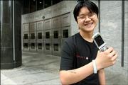 Steven Cao, 16, a sophomore at Stuyvesant High School in Manhattan, poses for a portrait in front of the school with his cell phone, Thursday, May 11, 2006, in New York. Cao lives on Staten Island and says, "My mother, she needs me to have the cell to call me and check up on me." A ban on cell phones in New York's school system is creating an uproar among parents and students alike, with teenagers smuggling their phones inside their lunches and down their pants, and grown-ups warning they need to stay in touch with their children in case of another crisis like Sept. 11.