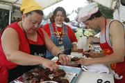 From left to right Stephanie WIlson, Valerie Wilson, and Kyle Laval, all of Tom and Josh's Orgasmic Slabs, prepare their entry for the chicken category of the Sertoma BBQ Contest. The Saturday afternoon contest was held at Broken Arrow Park.
