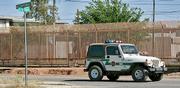 A border patrol agent rides along the iron fences that separates Douglas, Ariz., and Agua Prieta, Mexico. In a televised address tonight, President Bush will outline his plans for stationing National Guard troops along the border.