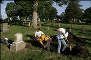 A crew digs up a grave at Oak Hill Cemetery in hopes of solving a 19th century mystery that led to a federal rule on hearsay evidence. Two Colorado professors spearheaded the dig. The exhumation crew includes, from left, Sarah Garner, Paul Sandberg and Ben Herr.