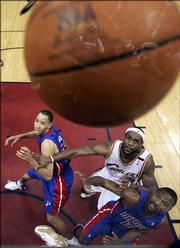 Detroit's Tayshaun Prince, left, and Lindsey Hunter, right, battle Cleveland's LeBron James for position on a rebound. The Pistons defeated the Cavaliers, 84-82, Friday night in Cleveland to even their series at three games apiece.