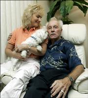 Former daredevil Evel Knievel sits with longtime partner Krystal Kennedy-Knievel and their dog, Rocket, in their condo May 11, 2006, in Clearwater, Fla. Evel Knievel, a 1970's cultural icon and poster boy for fast living and derring-do, has trouble now just walking from his condo to the pool. His 67-year-old body is broken by years of spectacular crashes and ravaged by a multitude of serious ailments.