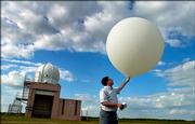 National Weather Service meteorologist intern Gordon Strassberg, Topeka, prepares to launch a weather balloon equipped with a transmitting device Tuesday at the National Weather Service station in Topeka. Although forecasting technology has improved greatly in the 40 years since a tornado caused massive damage in Topeka, balloons still are used to collect information from the upper atmosphere and play a key role in forecasts.