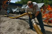Brian Barney hooks up a hose that will deliver 8,000 gallons of gas to the Presto Phillips 66 gas station, 602 W. Ninth St. Barney worked Tuesday at the station, which is expected to reopen in about two weeks. It has been closed since an April 30 fire at a nearby house.