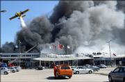 A firefighting plane drops a load of water over the cargo section at Istanbul's Ataturk International Airport in Turkey. A huge fire engulfed the cargo section of the airport and temporarily halted air traffic on Wednesday.