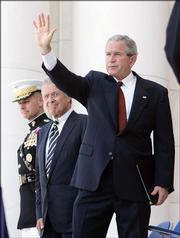 President Bush waves after speaking at Arlington National Cemetery Memorial Day commemoration. He and Defense Secretary Donald Rumsfeld attended the ceremony just a short time after Bush signed into law a bill that restricts protests at military funerals.