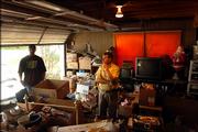 Auctioneer Doug Riat, center, and Aubrey Gilbert, move through the crowded garage of Gilbert's deceased grandmother Willie Stagg Thursday afternoon, as they prepare for a two-day auction this weekend in which the family will sell many of Stagg's possessions including her many collectibles. Among other things, according to Riat, Stagg carried a collection of over 200 Barbie Dolls, 2000 albums and 5000 miniature stuffed animals.