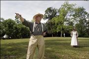 In clothing reminiscent of that worn in the mid-1800s, Jeff Quigley points to what was thought to be a blackjack oak tree during a tour of the Black Jack Battlefield. The battle occurred June 2, 1856. The anniversary was celebrated Saturday at the site. Quigley's wife, Kathy, is pictured at right.