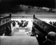 While under attack from German machine gunners, American soldiers wade ashore during the Allied landing operations on June 6, 1944, at Normandy, France.