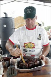 Lawrence barbeque enthusiast John Humphrey bastes a pork butt roast before submitting it to the judges at the McLouth BBQ Blowout Saturday. The annual competition, boasting about 40 teams, allows winners of each category to advance to the American Royal BBQ Invitational in October.
