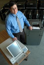 Jamie Shew, Douglas County clerk, displays the two styles of new computerized voting machines. Eighty of each machine will be tested and ready to put into use for the Aug. 1 elections.