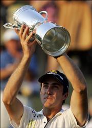 Geoff Ogilvy hoists the U.S. Open trophy. Ogilvy, of Australia, won the tournament at Winged Foot Golf Club on Sunday in Mamaroneck, N.Y., finishing at 5 over par.