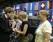 Katharine Jefferts Schori, left, of Nevada, the newly elected 26th Presiding Bishop of the Episcopal Church, shakes hands with members of the House of Deputies after her confirmation vote Sunday in Columbus, Ohio.