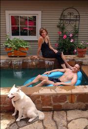 Constance Wolfe and John Novosel relax in their aquatic pond. The couple built two ponds last spring: one for them to relax in, and another for plants and fish. Their water garden is one of more than 20 stops on this year's Sunflower Water Garden Society's Water Garden tour this weekend.