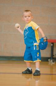 William Yanek prepares to throw the ball to his dad before a game of Blastball on June 19 at the East Lawrence Center. Participants warm-up with their parents or siblings before playing the game.