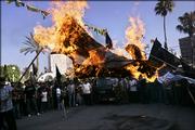 Palestinian supporters of Islamic Jihad chant slogans as they burn a likeness of an Israeli flag during a protest against Israeli army operations Friday in Gaza City.