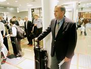 Mark Erickson, vice president of continuing education at the Culinary Institute of America, waits to board Delta Flight 656 for Newark at Hartsfield Jackson Atlanta International Airport. Erickson, of Marietta, Ga., is a super-elite frequent flier who travels 200,000 miles a year. He looks for perks such as first-class upgrades or being able to board first instead of getting free airplane tickets for his frequent business. "The last thing I want to do is travel (more)," he says.